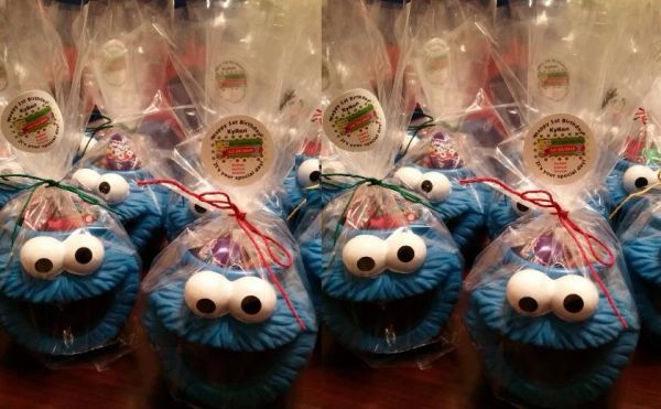 Cookie Monster cupcakes wrapped in clear plastic with birthday tags.
