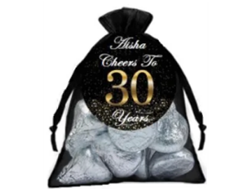 A black bag with silver chocolates and a label celebrating 30 years for Aisha.