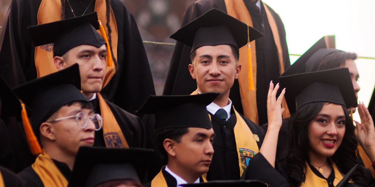 Group of graduates in caps and gowns during a ceremony.