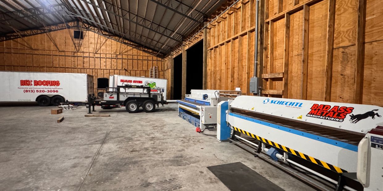 Industrial warehouse with metalworking equipment and trailers.