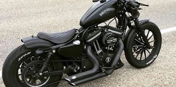 Black Harley-Davidson motorcycle parked on pavement.