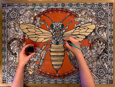 One copper circle and one bee in the middle. 