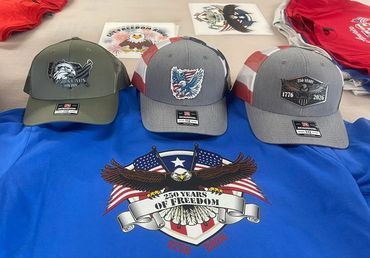 Three patriotic caps displayed above a blue shirt with a 250 years of freedom eagle design.