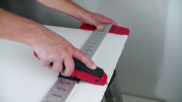 A man measuring the board with the pointer