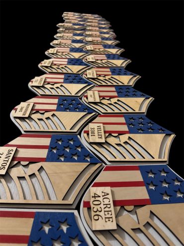 Wooden plaques with American flag designs and names lined up in a row.