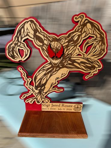 Wooden sculpture of a fierce creature with red eyes.
