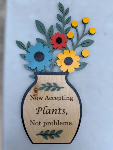 Wooden sign with colorful flowers and a motivational quote.