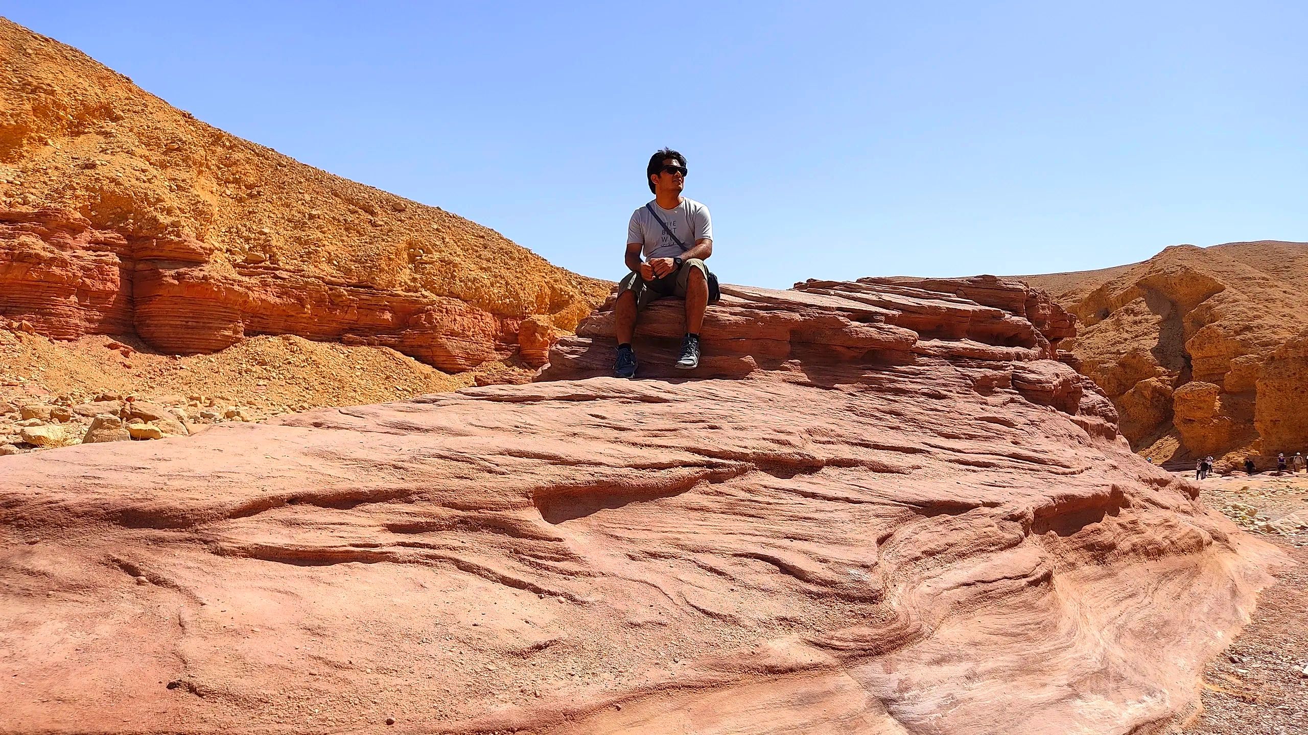 Nature enthusiast resting on a rock, surrounded by the beauty of Red Canyon, Israel