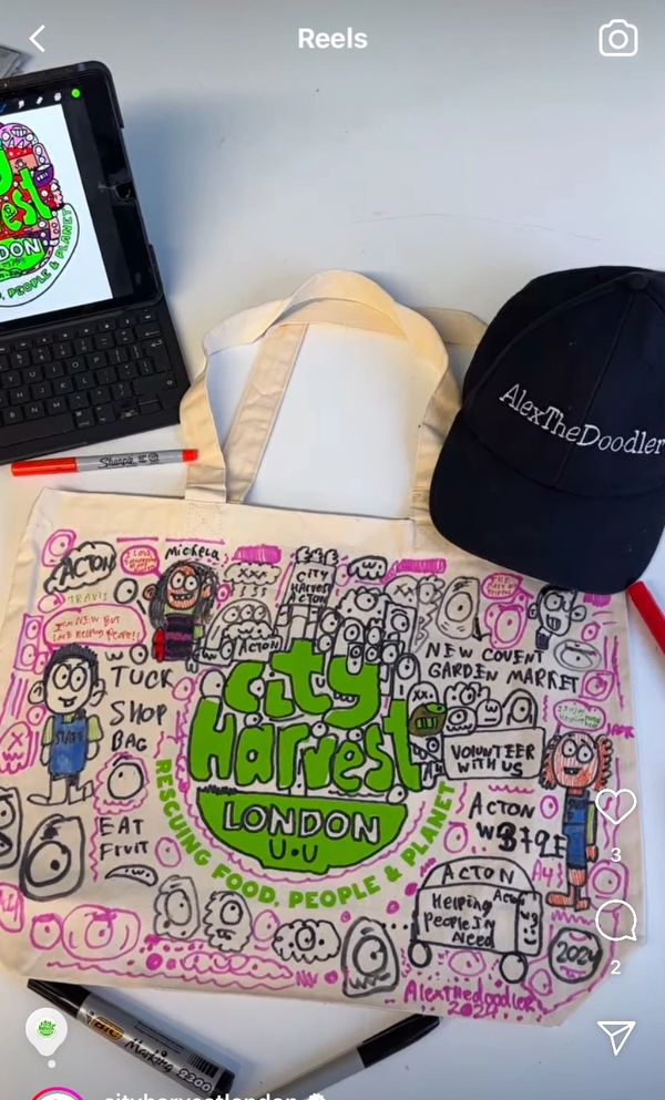A hand-decorated City Harvest London tote bag with doodles and messages about helping people.