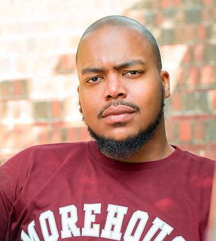 Man wearing a Morehouse shirt with a serious expression.