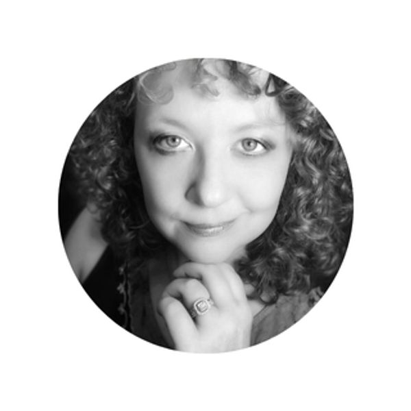 Black and white photo of a woman with light skin, curly hair, and a slight smile