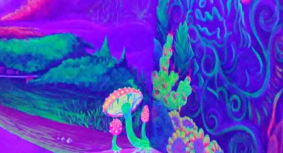 Black light sensitive UV painted mural with a blue man, coral, mushrooms, and landscape elements