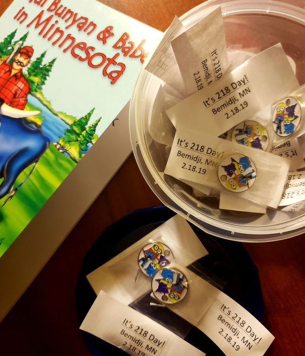 Buttons promoting "218 Day" in Bemidji, Minnesota with a Paul Bunyan book.