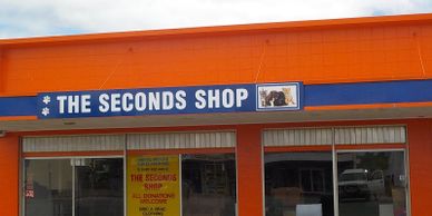 The Seconds Shop storefront with bright orange exterior and blue sign.