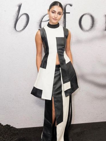 Woman in a stylish black and white sleeveless outfit posing against a light background.