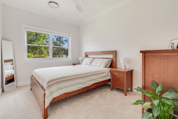 Bright bedroom with wooden furniture and a large window.