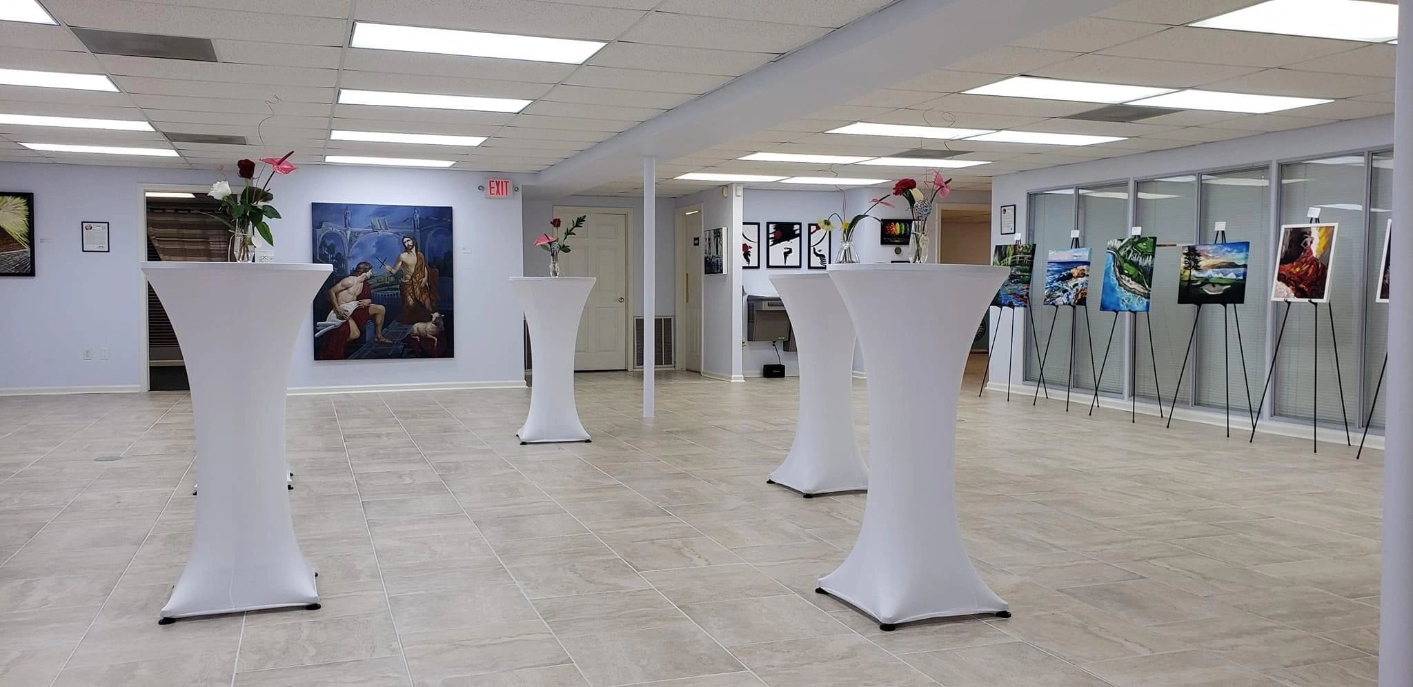 Gallery room with high tables and flowers.