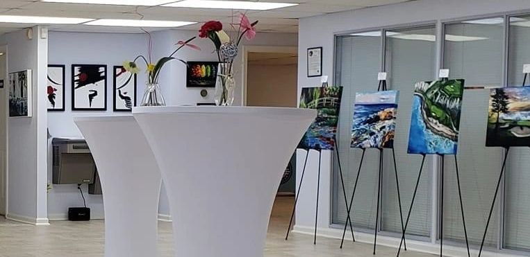 Art display in a modern gallery space with floral decorations.