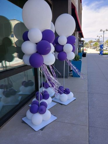 Purple and white balloon decorations outside a building.