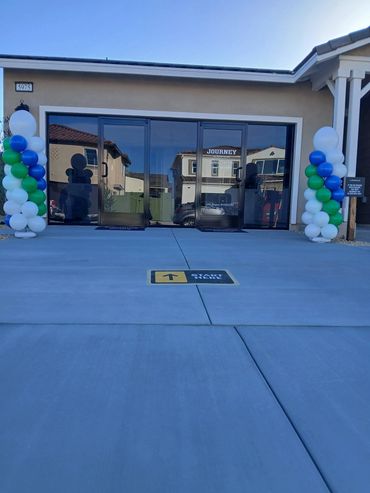 Entrance decorated with balloons and directional sign on the ground.