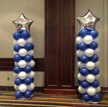Two balloon columns with blue and white balloons topped with silver star balloons.