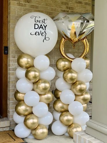 Elegant gold and white balloon columns with a diamond ring balloon and 'Best Day Ever' message.
