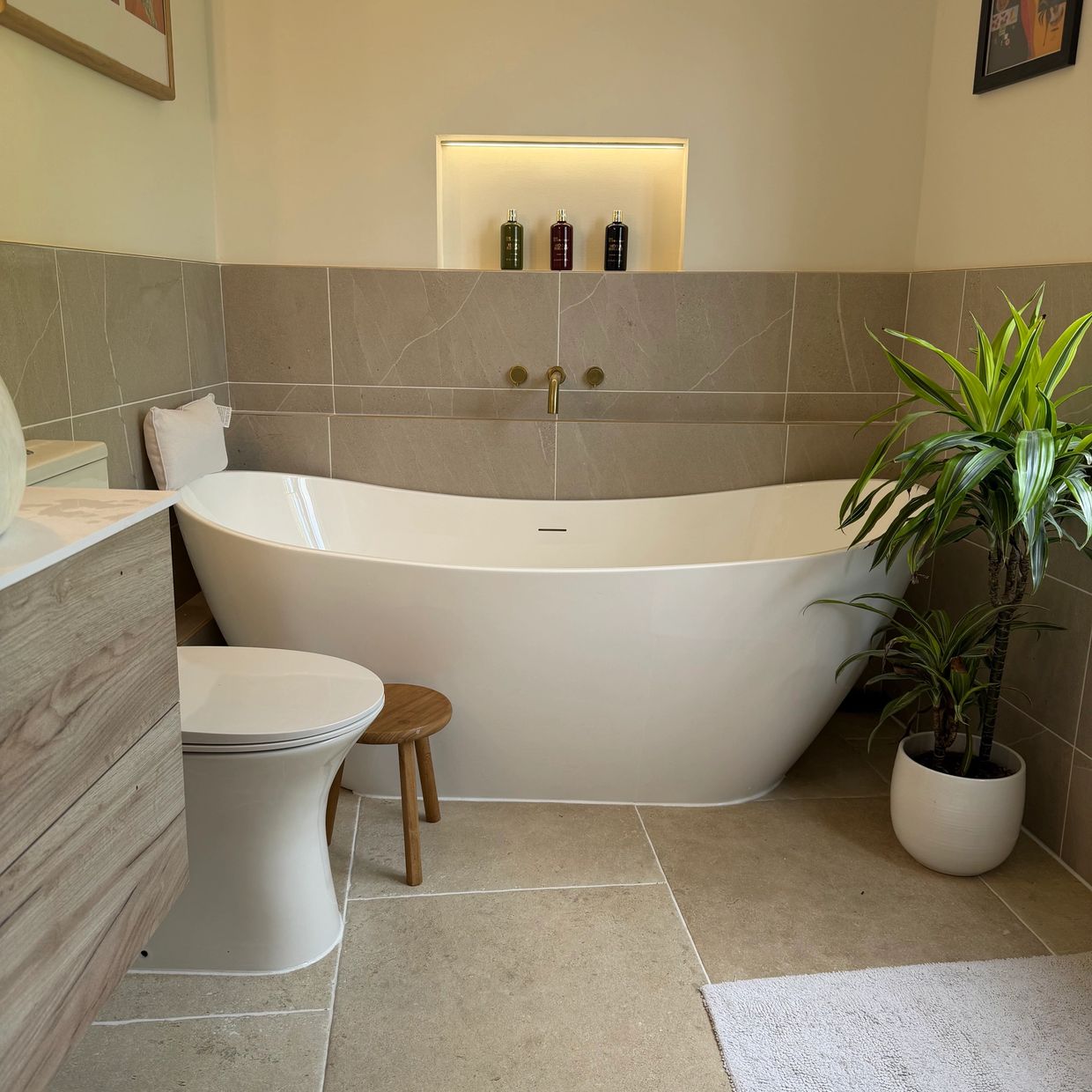 Modern bathroom with a freestanding bathtub and plant.