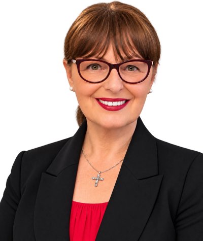 Smiling woman with glasses and cross necklace.