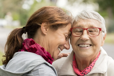 Two women sharing a joyful moment outdoors.