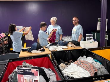 Volunteers sorting donated clothes at a community clothing drive.