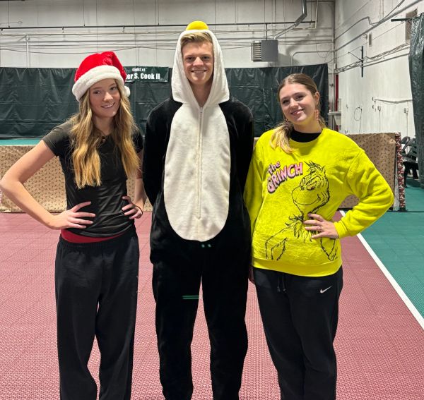 Three people in festive holiday attire posing indoors.