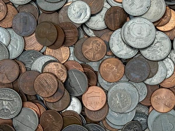 A pile of mixed U.S. coins including pennies, nickels, and dimes.