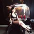 Dominatrix Poppin Cherries Goddess rests on chair ahead of Fuseli The Nightmare art in her dungeon .