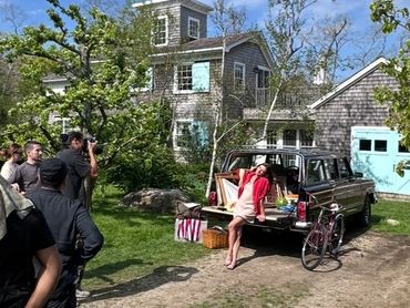 Woman posing on pickup truck bed during a photo shoot.