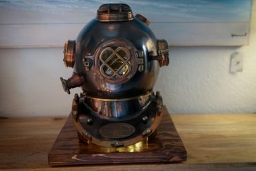 Vintage deep-sea diving helmet on a wooden base.