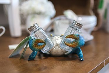 Decorative crab-shaped salt and pepper shakers on a wooden surface.