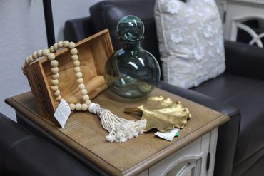 Decorative items on a wooden side table with a leather sofa in the background.