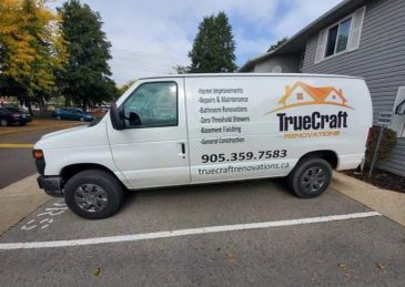 White TrueCraft Renovations van parked near a house with service details.
