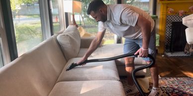 Matthew Perez performing steam extraction on a white sofa