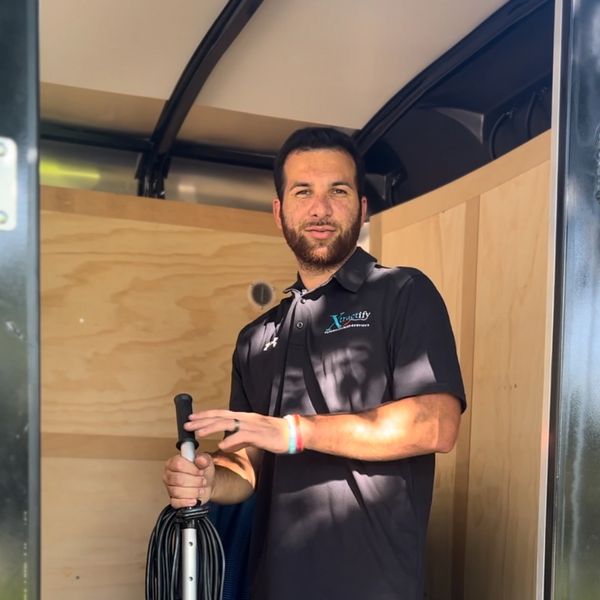 Man standing in carpet cleaning trailer and smiling 