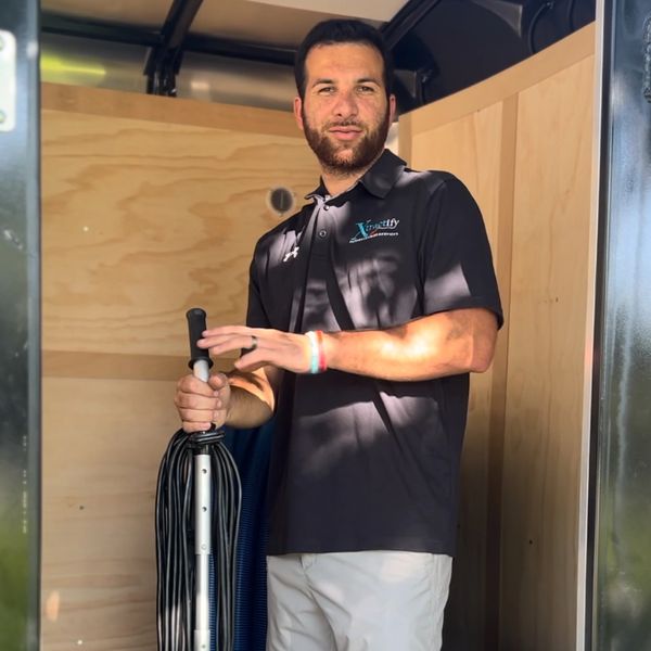 Man standing in carpet cleaning trailer and smiling 