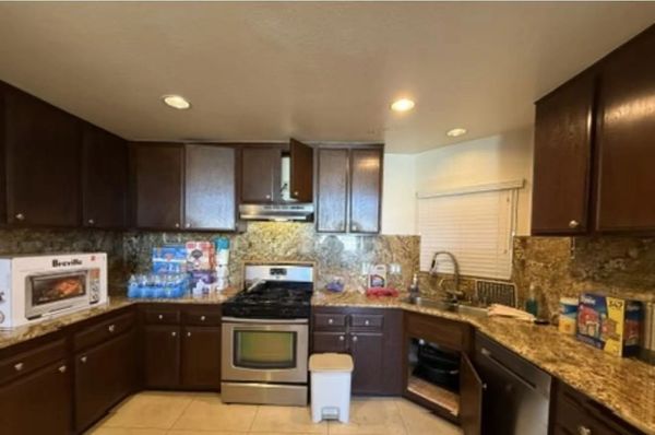 Modern kitchen with dark cabinets and granite countertops.