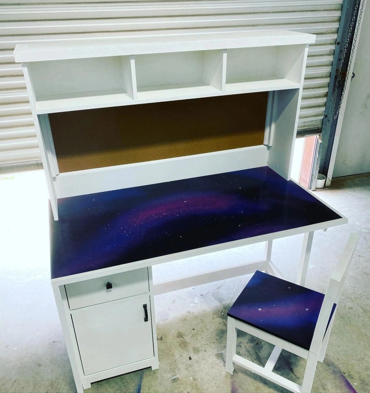 White desk and chair with galaxy-themed surfaces.