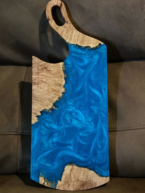 Wood and blue resin cutting board with handle.