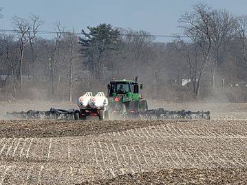 Tractor tilling a field on a clear day.
