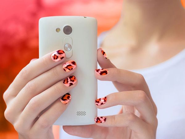 Women holding a cell phone and dialing with manicured fun nails