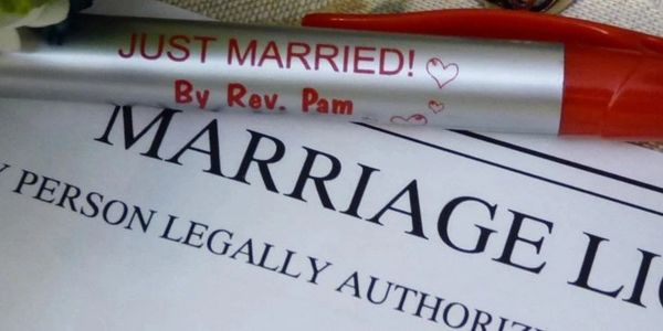 Close-up of a marriage license and a pen.