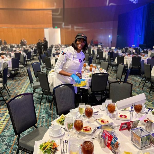 Chef preparing food in a banquet hall.