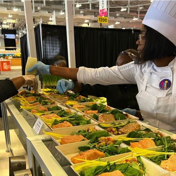 Chef serving prepared meals at a food station.