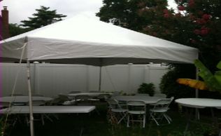 White tent with round tables and white folding chairs